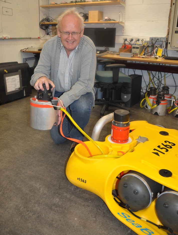 Eivind Berg er oppfinner. Ingen bestrider at han er mannen bak 4C-seismikk etter at ideen ble sådd sent på 1980-tallet. Her står han med en CASE Abyss (”Cableless Seismic”) node hvor den gule boksen med hard-disk, elektronikk og batterier ligger på bunnen, mens den grå sylinderen inneholder tre geofoner, en hydrofon og inklinometer og er plantet ned i bunnen for å sikre et godt signalmottak. Foto: Halfdan Carstens