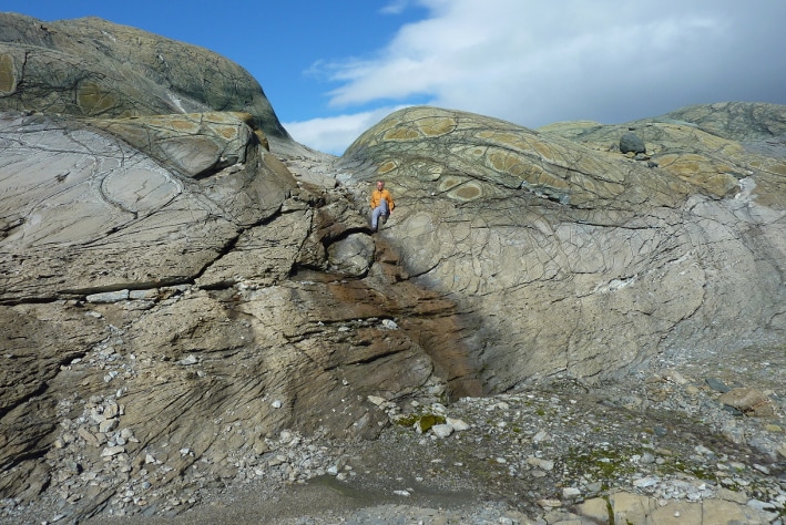 Serpentinitt (grønn og brun bergarter øverst i bildet) erstattes av magnesittrik kleberstein (grå bergart i nedre halvdel av bildet). Fra Linnajavriområdet i Nordland. Foto: Oliver Plümper, PGP.