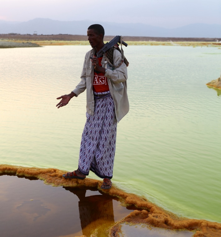 Vannet med svovel og jernrike utfellinger tilhører den varme kilden på toppen av Mount Dallol. I bakgrunnen ser vi det etiopiske høylandet som ligger utenfor riftdalen. Foto: Jørgen Stenvold
