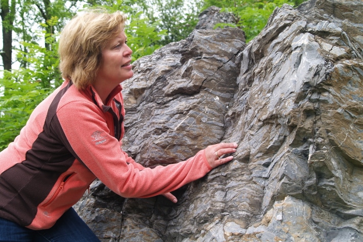 Kristin Rangnes er daglig leder i Gea Norvegica Geopark og styrer over et steinrike med røtter i prekambrium, kambrosilur, karbon, perm og kvartær. En god del kontorarbeid må det naturligvis bli på en sjef, men aller helst tar hun turen ut og forteller om stein, geologiske prosesser og geologiens plass i samfunnet til alle om vil høre på. Og det er det mange som vil. Unge og gamle. Leg og lærd. Foto: Halfdan Carstens