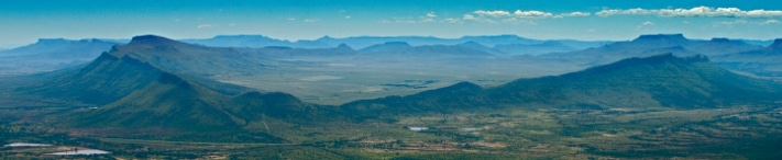 The saucer shape of the Golden Valley can be clearly seen in this aerial photograph. The sides of the saucer comprise erosionally resistant dolerites, while the Golden Valley itself is formed by a 100 m thick dolerite sheet. The steep flanks of this sheet cross-cut the sub-horizontally layered fluvial sandstones and shales of the Beaufort Group. The valley is about 200 km north of Port Elizabeth and over 650 km south-south-west of Johannesburg. Photo: Stephane Polteau, PGP.